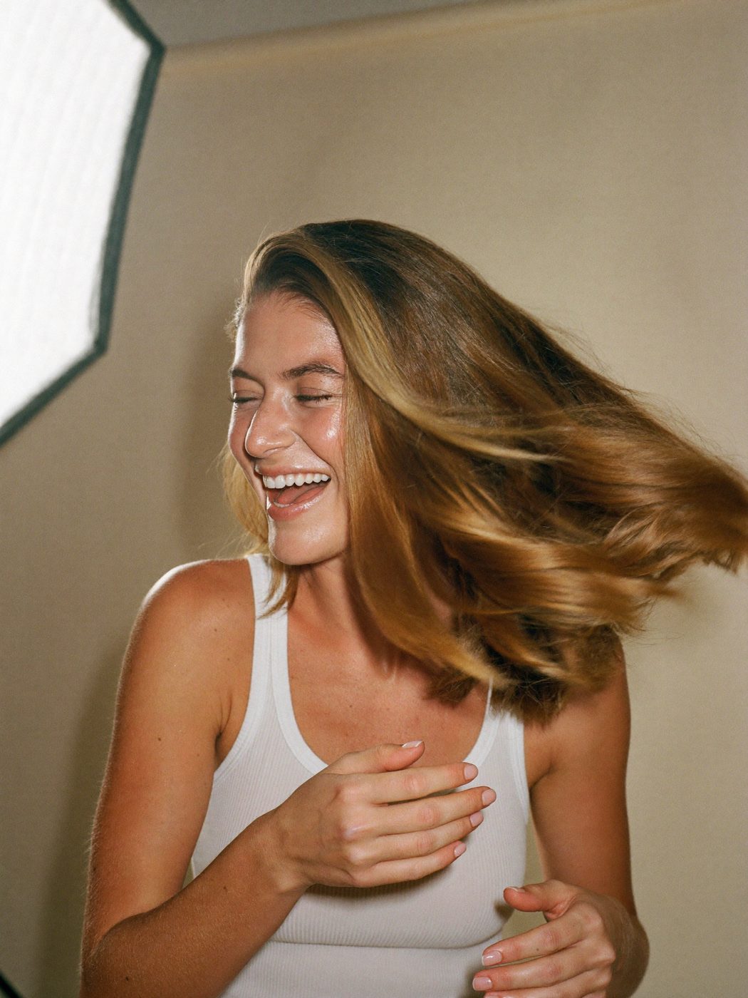Model laughing mid hair flip